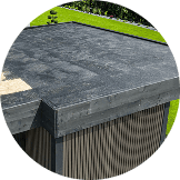 Flat roof with dark, textured Pantheon Roofing material on a modern outdoor structure, surrounded by green grass—perfect for the Florida climate.
