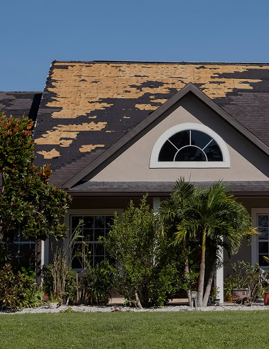 A house in Florida with a partially damaged roof, missing many shingles and exposing the underlying wooden structure, is in need of expert care from Pantheon Roofing.